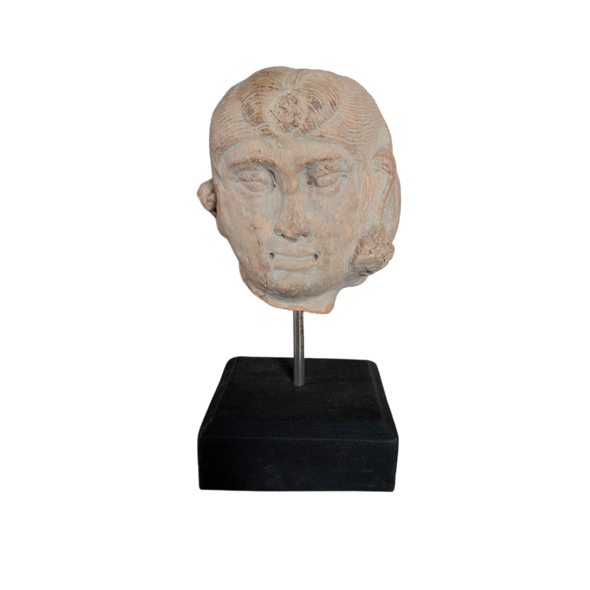 Stone sculpture of a head on a black stand against a white background