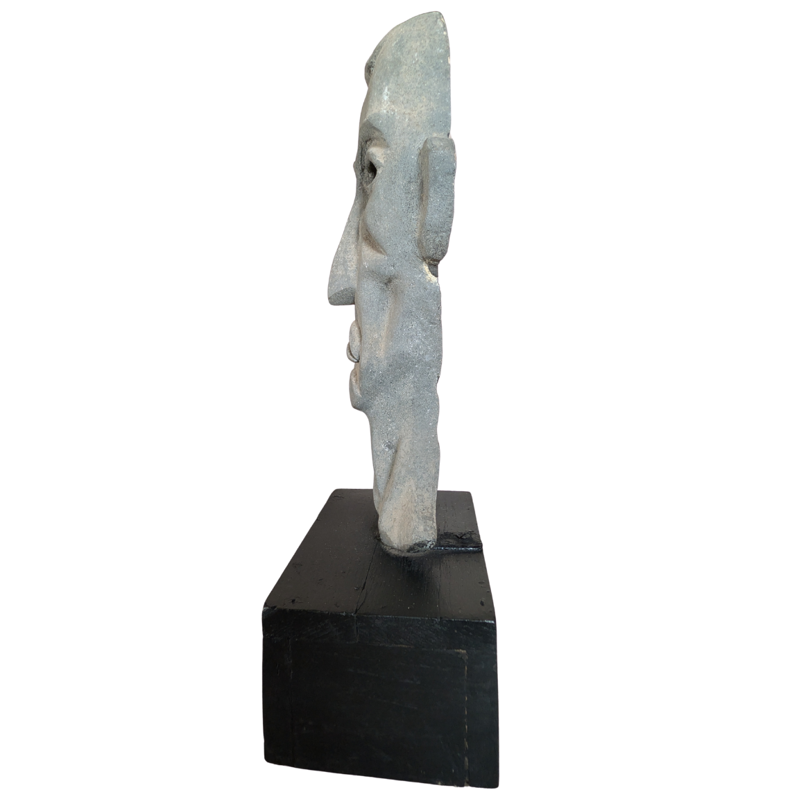 Carved stone face sculpture on a black base against a white background