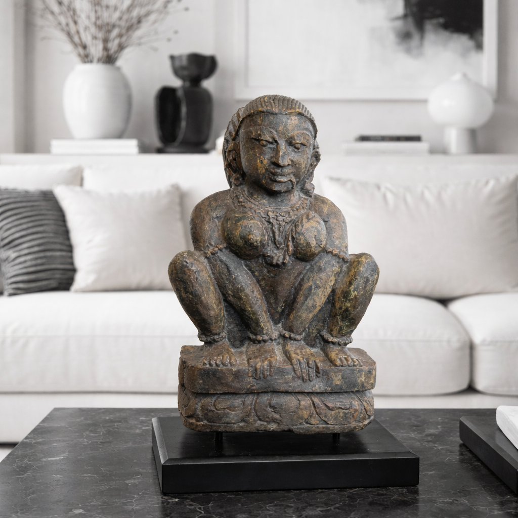 Decorative statue on a black marble table in a living room setting.
